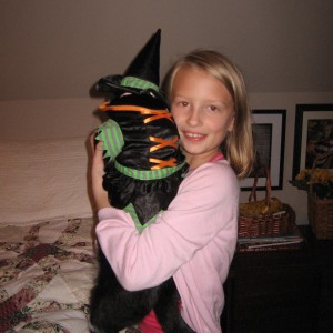 Sarah holding Oreo wearing her witches hat
